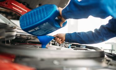 Technician change oil in the car engine